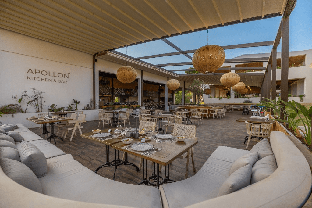 Terras van Apollon Kitchen & Bar met houten tafels en hanglampen